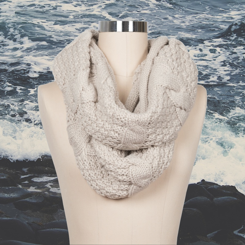 Beige cable knit infinity scarf on rolling water background