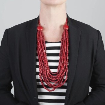 Red wooden bead necklace worn over a stripe top with a black blazer